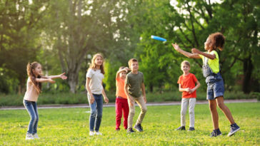 Cute little children playing with frisbee outdoors on sunny day