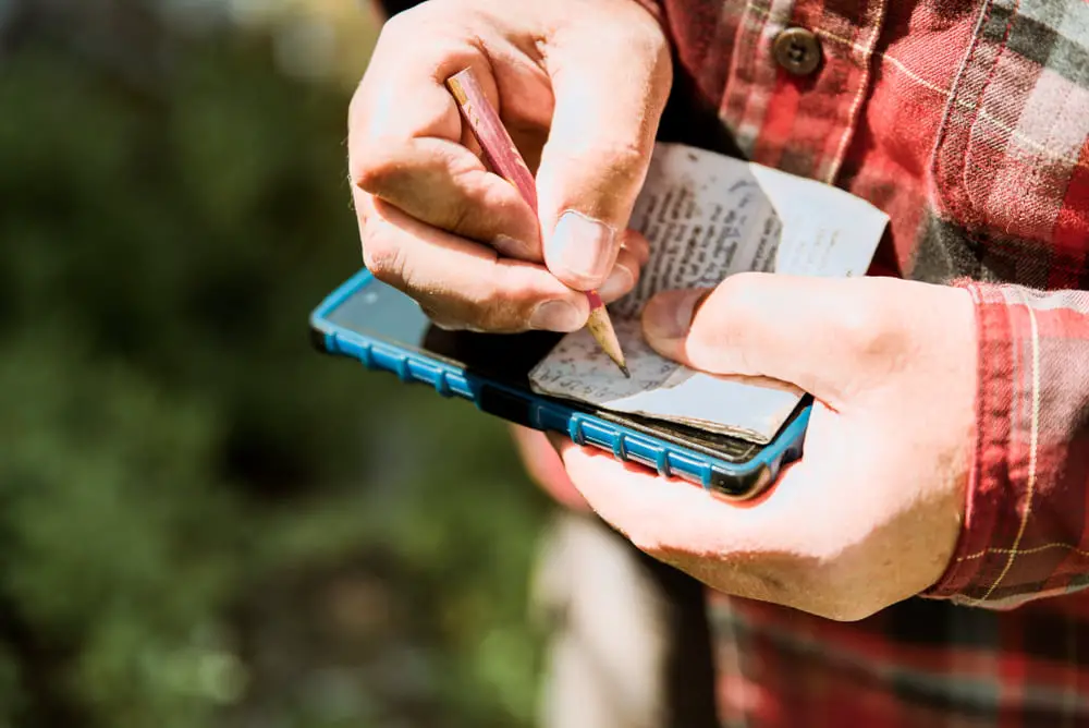 Man writing notes while geocaching