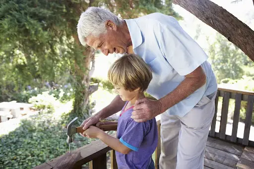 Grandfather helping grandchild with woodworking