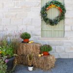 Fall-DIY-porch-decor-with-hay-bales-small-pumpkins-and-flower-pots