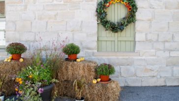 Fall-DIY-porch-decor-with-hay-bales-small-pumpkins-and-flower-pots
