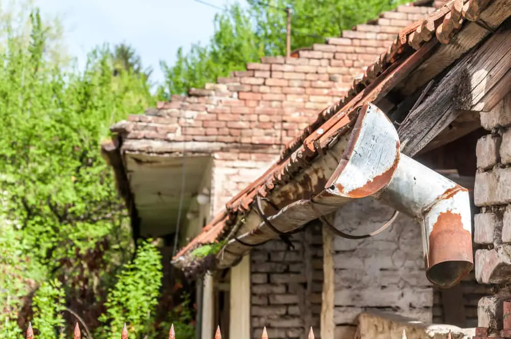 Old rusty gutters falling off roof